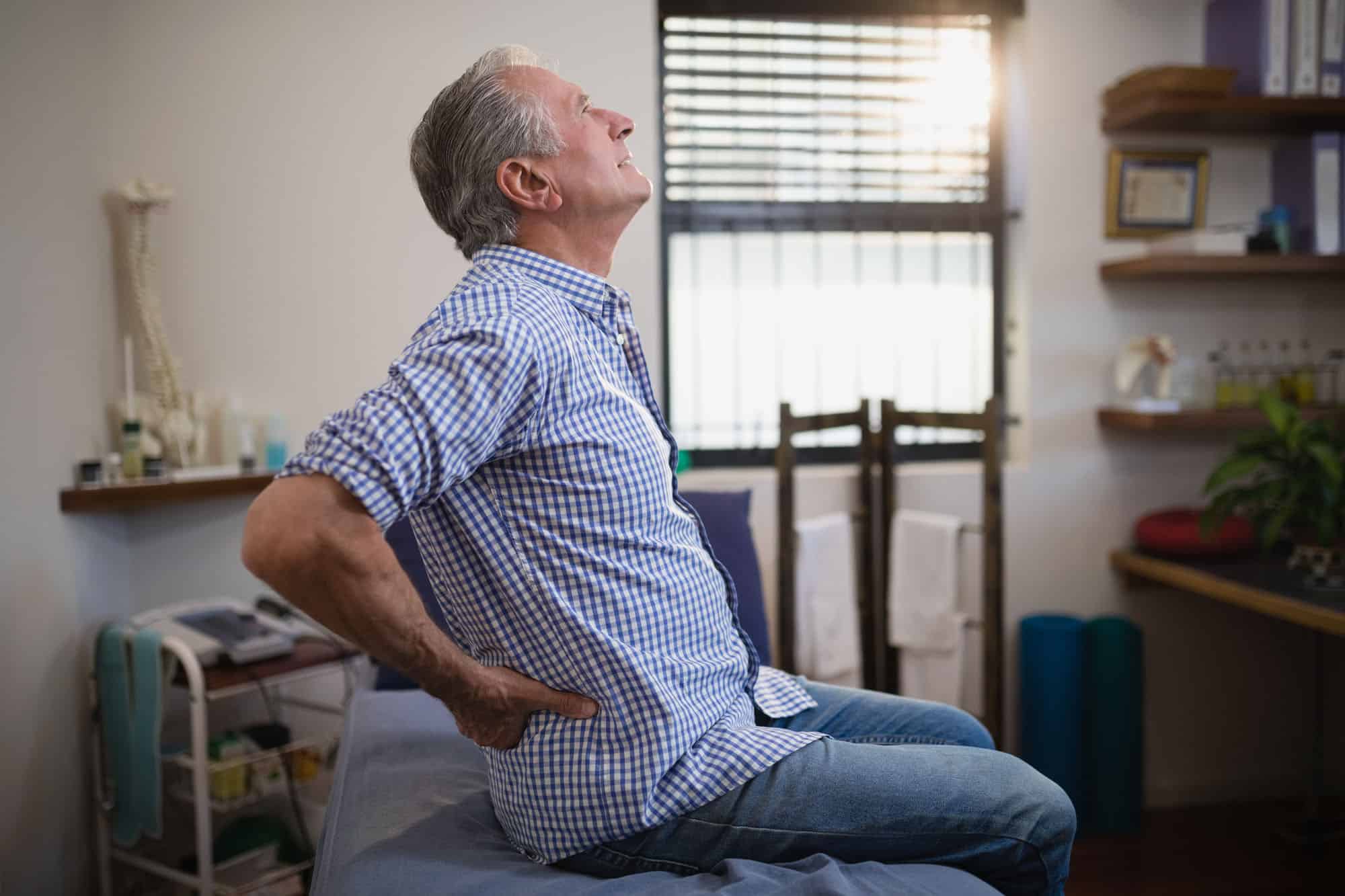 A man with back pain in a doctor's office.